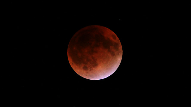 皆既月食で赤く色づいた月の表面